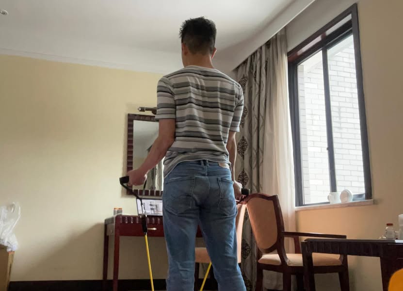 隔離ホテルの室内でトレーニングチューブを使う佐藤大介
