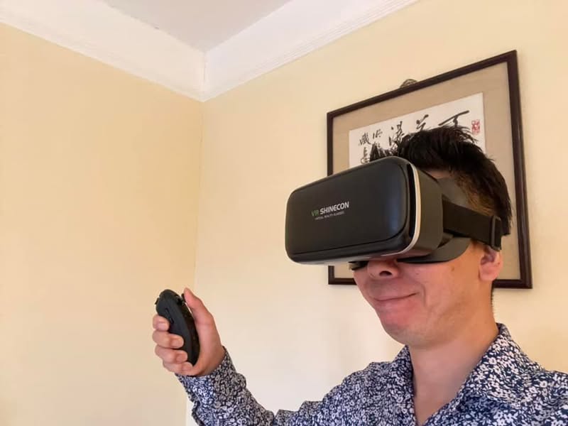 隔離ホテルの室内でVRゴーグルを装着する佐藤大介