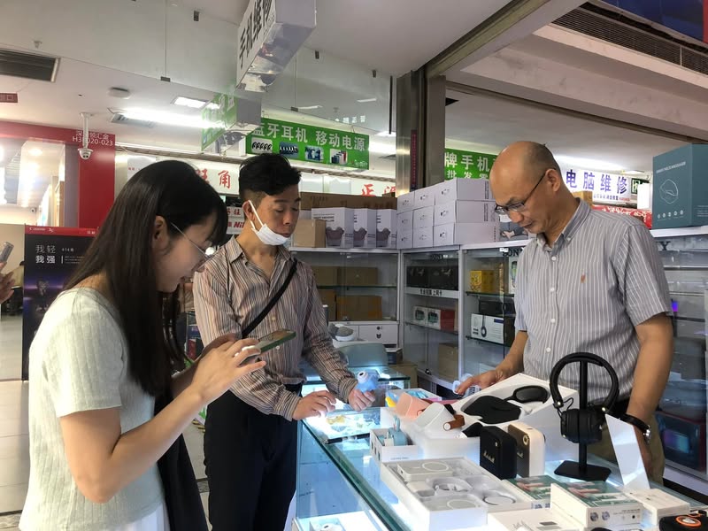 華強北の売り場で商品を確認する佐藤大介と社員