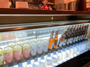 飲み物が並ぶSakura Coffeeのカウンターに立つスタッフ