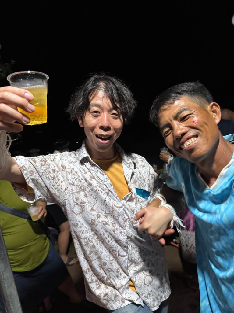 バーシーの白い木綿糸を手首に結び現地の人と祝杯を交わす佐藤大介