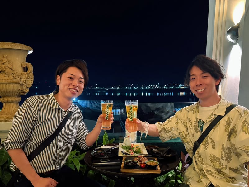 ラオスで事業を始める日本人経営者と乾杯する佐藤大介