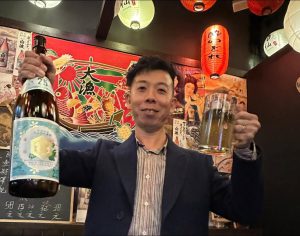 酒仙の店内で日本酒とジョッキを掲げる佐藤大介