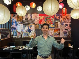 酒仙の店内でビールを手にする佐藤大介