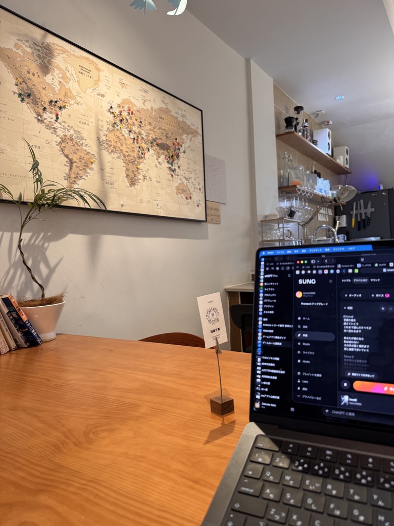 カフェのノートパソコンでSunoを開きWORD MASTERの音楽を試している様子
