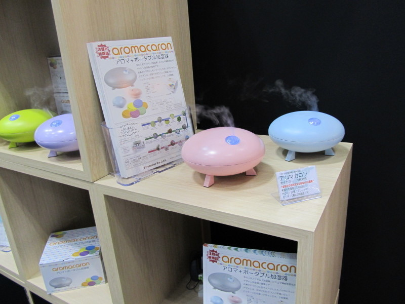 展示棚に置かれ、蒸気を出しているピンクと水色のアロマ加湿器