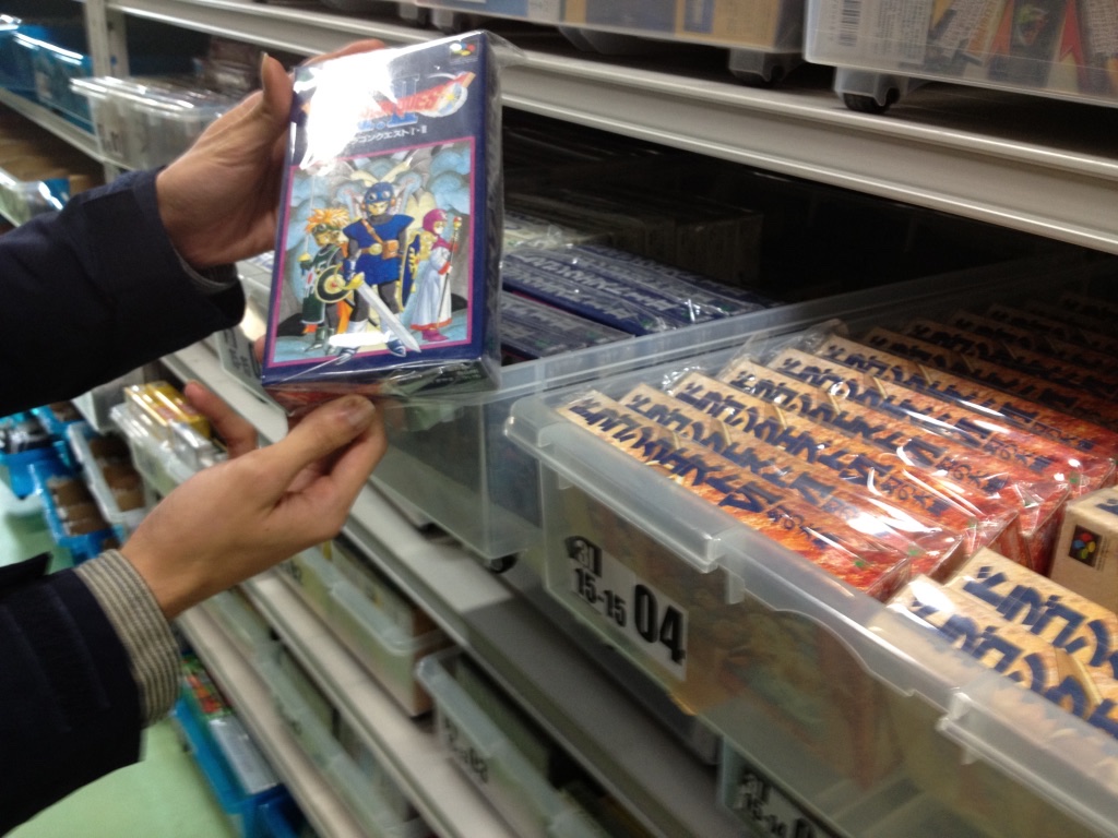 棚から中古ファミコンソフトを取り出す様子