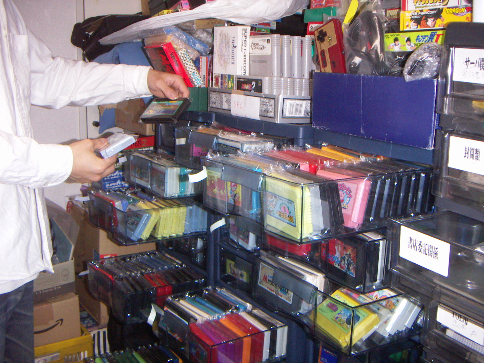 分類して保管した中古ファミコンソフトを手に取る様子